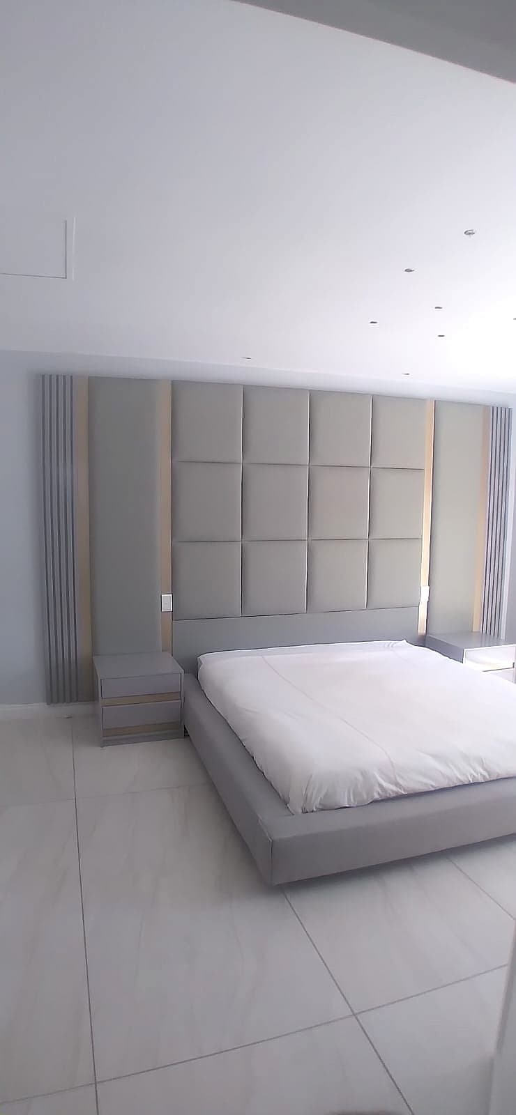 Square-tufted panel headboard styled with a bedside nightstand